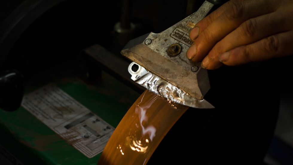 Messerschmied Michael Schimmel beim Schleifen einer Messerklinge © Janos Freuschle